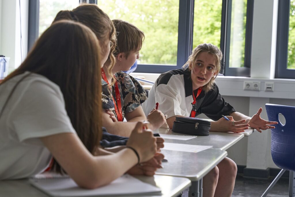 Gruppe von Jugendlichen arbeitet in einem Klassenzimmer zusammen