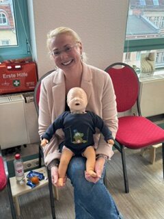 Erste-Hilfe-Kurs am Kind in der Paul & Paula Akademie mit Teilnehmer:innen und Trainer.